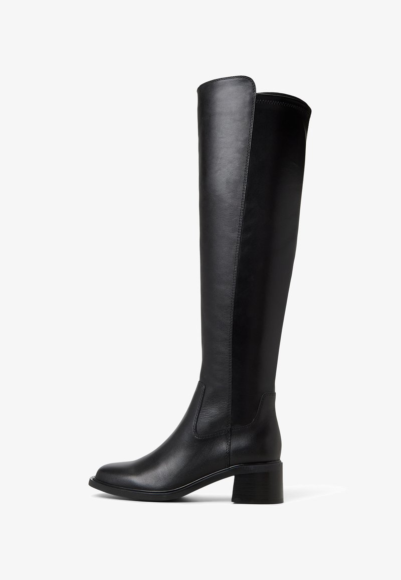 Botas de cuero negras hasta la rodilla con un acabado suave, punta redonda y un ligero tacón cuadrado. Panel lateral decorativo para un detalle de diseño adicional.