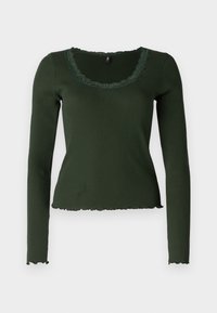 Langermet, mørkegrønn ribbestrikket topp med scallop-formet halslinning og nederkant. Har blonderdetaljer rundt halslinningen for ekstra tekstur.