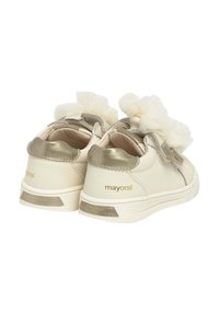 Sneaker color crema con un accento dorato lucido, dotate di un fiocco in tulle sulla parte superiore e strisce in velcro. Superficie testurizzata con branding minimo.