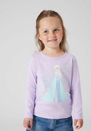 Jasnofioletowa koszulka z długim rękawem z grafiką postaci w niebieskiej sukience, ozdobioną płatkami śniegu i błyszczącym tekstem.