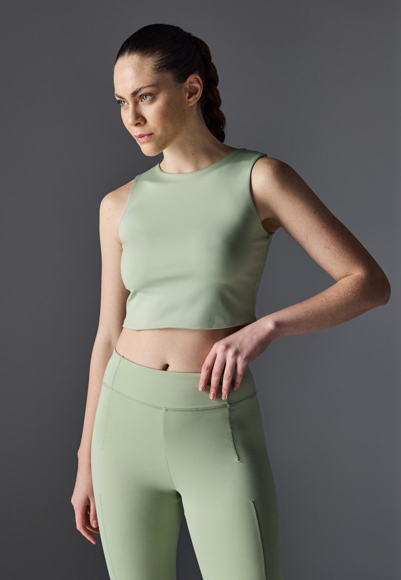 Top corto ajustado de color verde menta con un escote redondo, combinado con leggings de tiro alto a juego. Ambos artículos tienen una textura suave y costuras mínimas.
