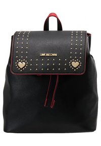 Sac à dos Moschino noir avec bordure rouge, clous dorés, deux ornements en forme de cœur doré et fermeture à rabat supérieur.