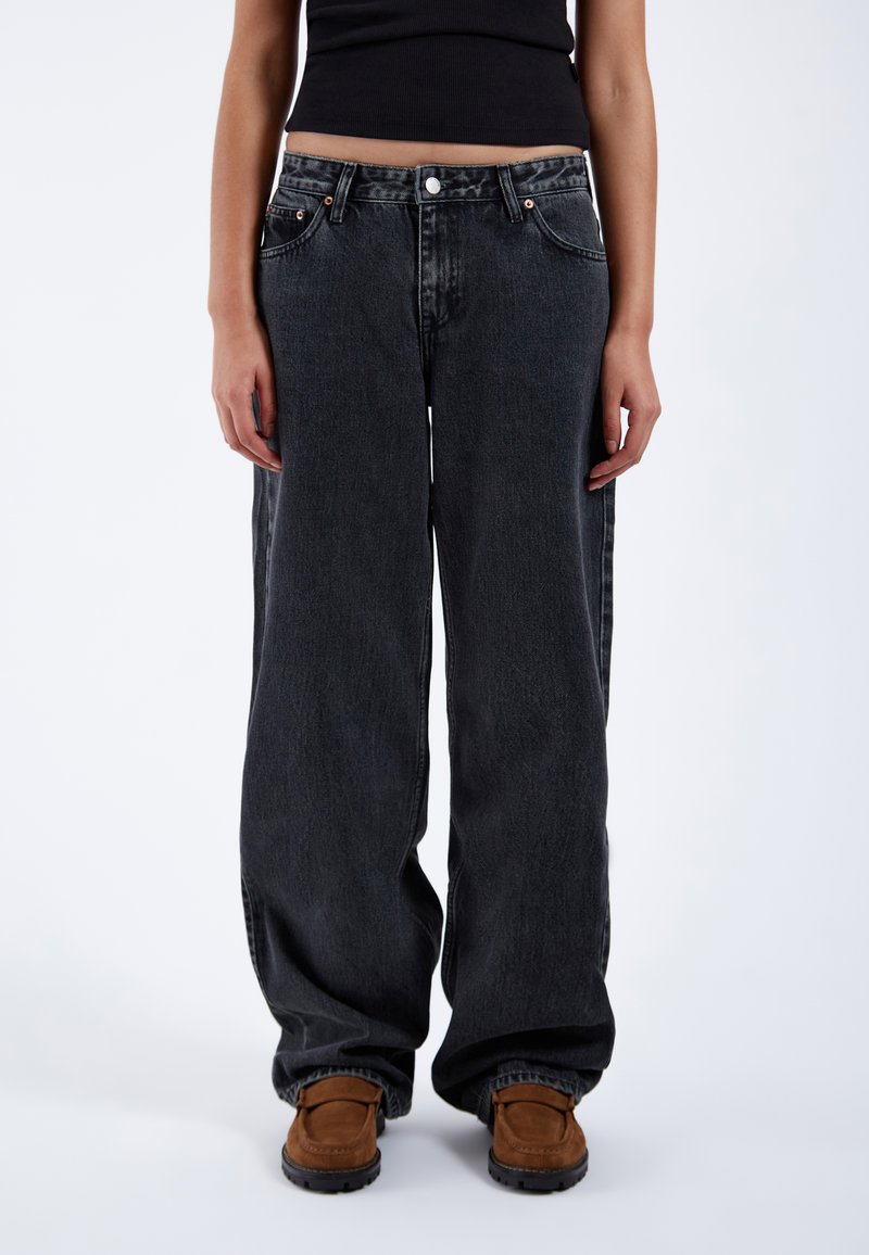 Black wide-leg jeans made from denim, featuring a classic button closure, five pockets, and visible stitching details.