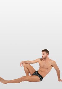 Schwarze bedruckte Unterhosen, die an einem Modell präsentiert werden; verfügen über eine weiche Textur, eine enganliegende Passform und einen kontrastierenden Bund mit floralem Design.