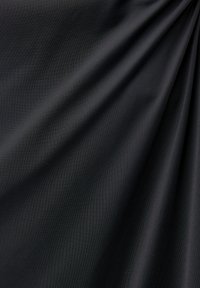 Tissu noir avec une texture lisse et un léger éclat, présentant des motifs de vagues subtils et des plis à travers la surface.