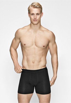 Sorte boxer briefs med en glat tekstur og en tætsiddende design, der har en formsyet frontpanel og en blød elastisk talje.