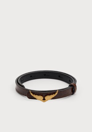 Bracelet en cuir brun avec une finition brillante, présentant un accent métallique doré en forme d'ailes, ajustable avec plusieurs trous.
