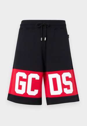 Čierne a červené šortky s elastickým pásom na šnúrku, s veľkými bielymi blokovými písmenami "GCDS" na prednej dolnej časti.