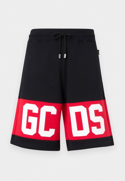 Μαύρο και κόκκινο σορτς με ελαστική μέση και κορδόνι, με μεγάλα λευκά γράμματα σε κεφαλαία "GCDS" στο μπροστινό κάτω μέρος.