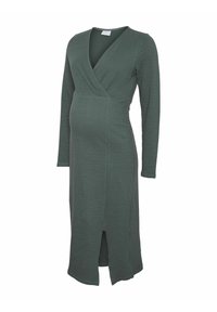 Langsleeve, wikkel-stijl zwangerschapsjurk in donkergroen, met een textuurstof en een split aan de voorkant voor meer bewegingsvrijheid.