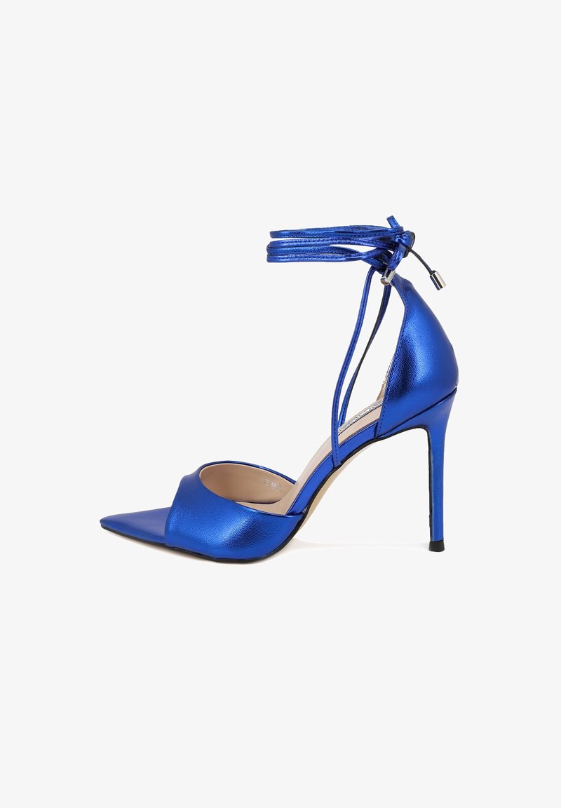 Sandalo alto con tacco metallic blue, punta affusolata, cinturino alla caviglia e tacco sottile. Presenta una superficie liscia e un design minimalista.