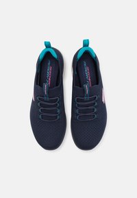 Zapatillas de tela de color navy con un diseño de malla, con acentos en turquesa, cordones flexibles y un logo rosa en el lado.