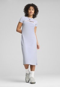 Robe bleu clair, longueur genou avec des manches courtes et un détail découpé à l'avant, en tissu doux. Assortie avec des baskets grises et des chaussettes blanches.
