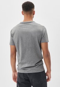 T-shirt in cotone grigio con maniche corte, colletto girocollo classico e vestibilità rilassata. Tessuto testurizzato con una finitura liscia, senza motivi o dettagli.