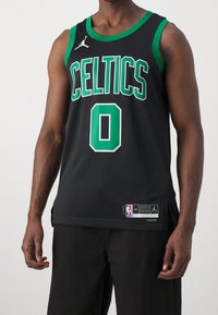 Canotta da basket nera con accenti verdi, testo "CELTICS" e numero "0" in grassetto. Realizzata in tessuto a rete con fessure laterali. Include etichetta del logo NBA.