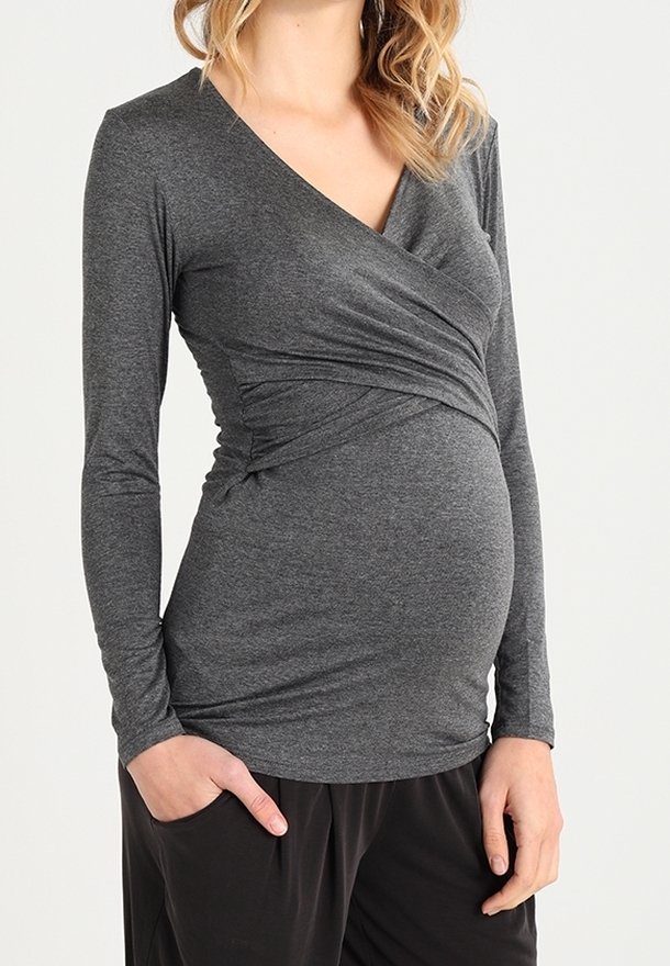 Graues langärmliges Stilloberteil mit Wickeldesign, aus weichem, elastischem Material, das einen wachsenden Bauch bequem umschließt. Schlichte, klare Linien.