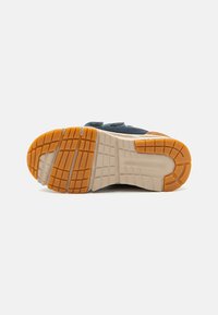 Sula till skor med en mångtydig gummidesign i orange och beige, med ett mönster för grepp och hållbarhet.