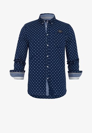 Navy blue button-up shirt with white small star pattern, long sleeves with contrast cuffs, and a chest patch logo. Made of fabric.