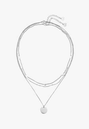 Collier superposé en argent avec plusieurs chaînes fines, de petits disques circulaires et un pendentif rond plus grand sur la couche la plus longue.