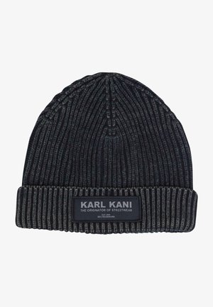 Melnas ribota trikotāžas cepure ar saliektu mali. Iekļauta auduma birka ar tekstu "KARL KANI" un papildu tekstu. Teksturēts audums siltumam.