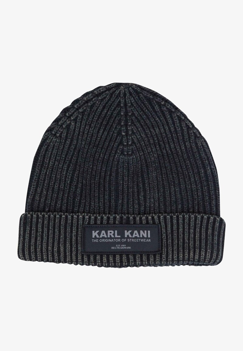 Fekete bordás kötött sapka hajtott mandzsettával. Jellemzője egy "KARL KANI" feliratú textilcímke és egyéb szövegek. Texturált anyag a melegségért.