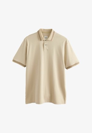 Beige poloshirt med en tekstureret krave med græsk nøglemønster, to knapper og korte ærmer. Fremstillet af blødt bomuldsmateriale.