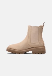 Bottine Chelsea beige à la cheville avec des panneaux latéraux élastiques, une languette à l'arrière et une semelle épaisse en caoutchouc texturé pour une bonne accroche.