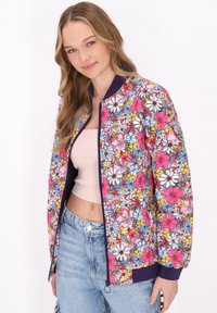 Bloemige bomberjack met een levendig patroon van roze, blauwe en gele bloemen. Contrast navy geribbelde kraag en manchetten, ritssluiting aan de voorkant.