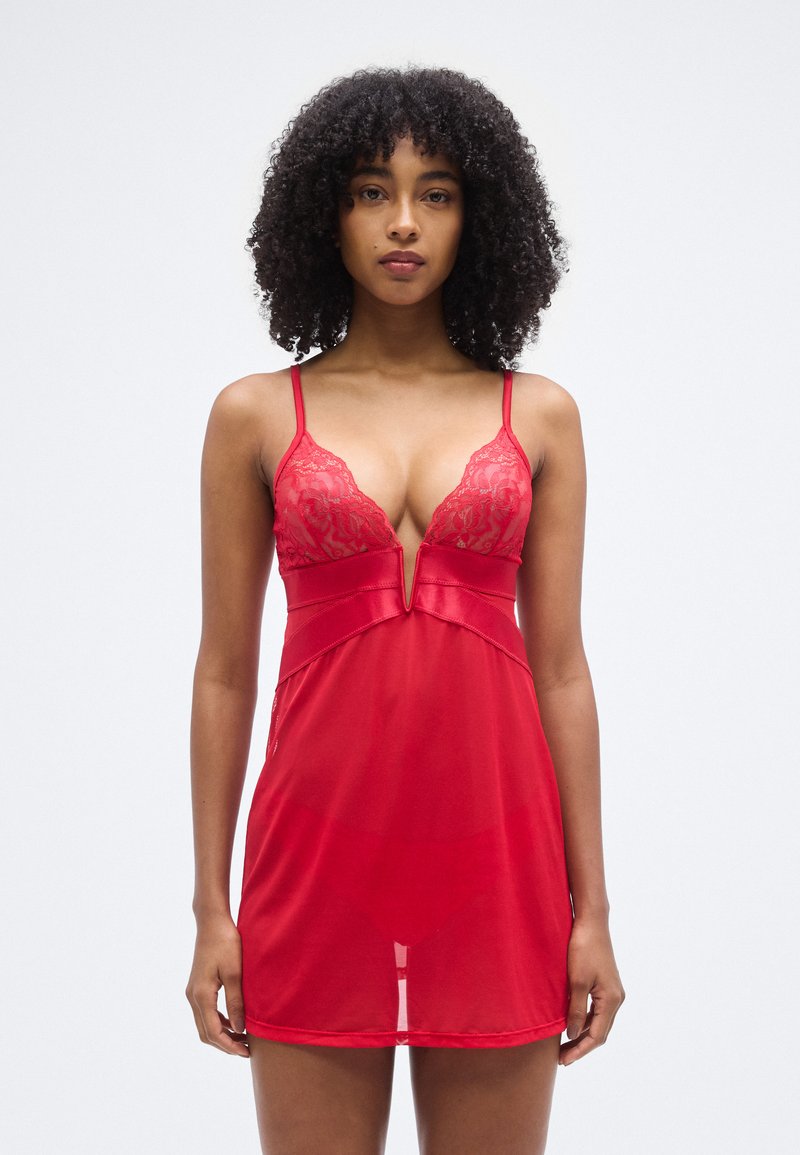 Κόκκινο νυχτικό από διάφανο ύφασμα, με δαντελένιες λεπτομέρειες στο μπούστο και βαθύ V-λαιμόκοψη. Ρυθμιζόμενες λεπτές τιράντες.