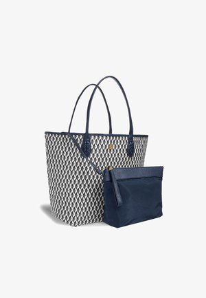Die Tragetasche verfügt über ein gewebtes geometrisches Muster in Weiß und Schwarz, marineblaue Lederakzente, zwei Griffe und einem abnehmbaren marineblauen Beutel.