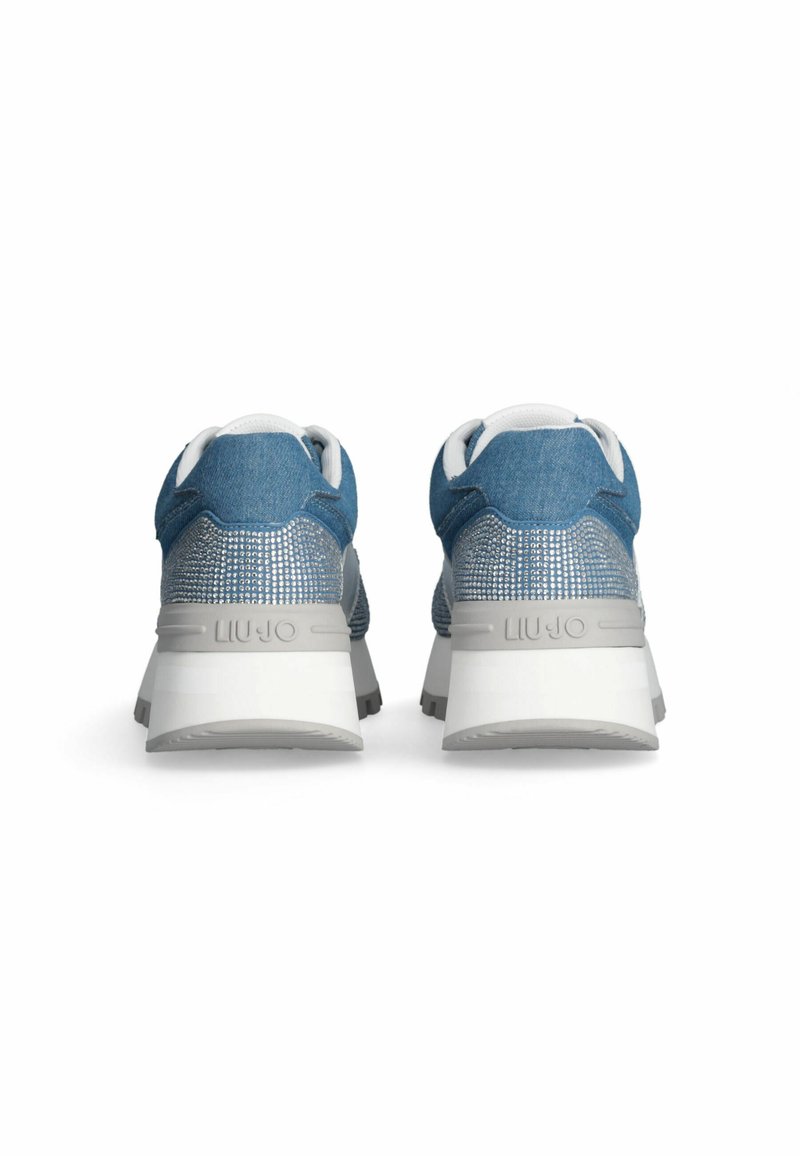 Jeans-Sneaker mit einem blauen Obermaterial, grauen Akzenten und einer strukturierten Ferse, die mit Strasssteinen verziert ist. Weiße Zwischensohle und graue Außensohle.