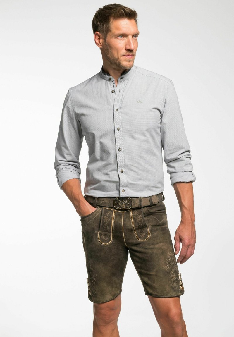 Graues Button-up-Hemd mit Bandkragen, kombiniert mit braunen Leder-Shorts, die mit dekorativen Nähten und einer metallischen Gürtelschnalle versehen sind.