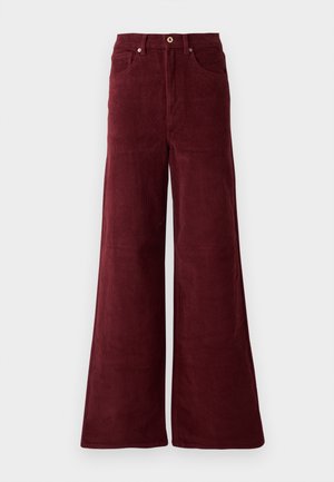 Pantalons en velours côtelé large de couleur bordeaux, avec une taille haute, des poches avant et une fermeture à bouton. Tissu texturé à côtes sur toute la surface.
