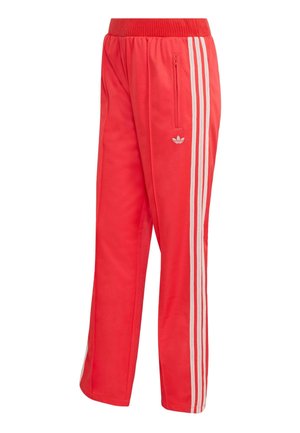 Crvene sportske hlače od glatkog materijala, s uskim strukom, džepom na patentni zatvarač i trima bijelim bočnim prugama s malim logotipom.