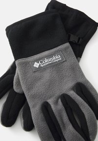 Guantes de forro polar en negro y gris con el logo de Columbia. Cuentan con una correa de velcro para ajustar y un diseño de dedos que proporciona calidez y flexibilidad.