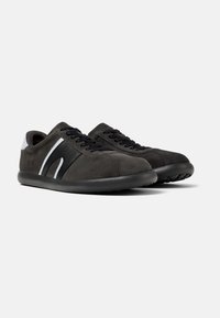 Black suede sneakers with white accents, round toe, flat black outsole, and lace-up closure. Texture is soft with a smooth finish.