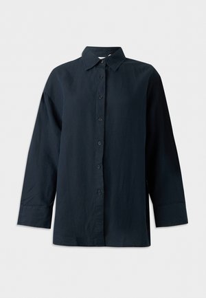 Svart skjorte med lang erme, knapper, krage, strukturerte mansjetter og rett kant, vist på hvit bakgrunn.