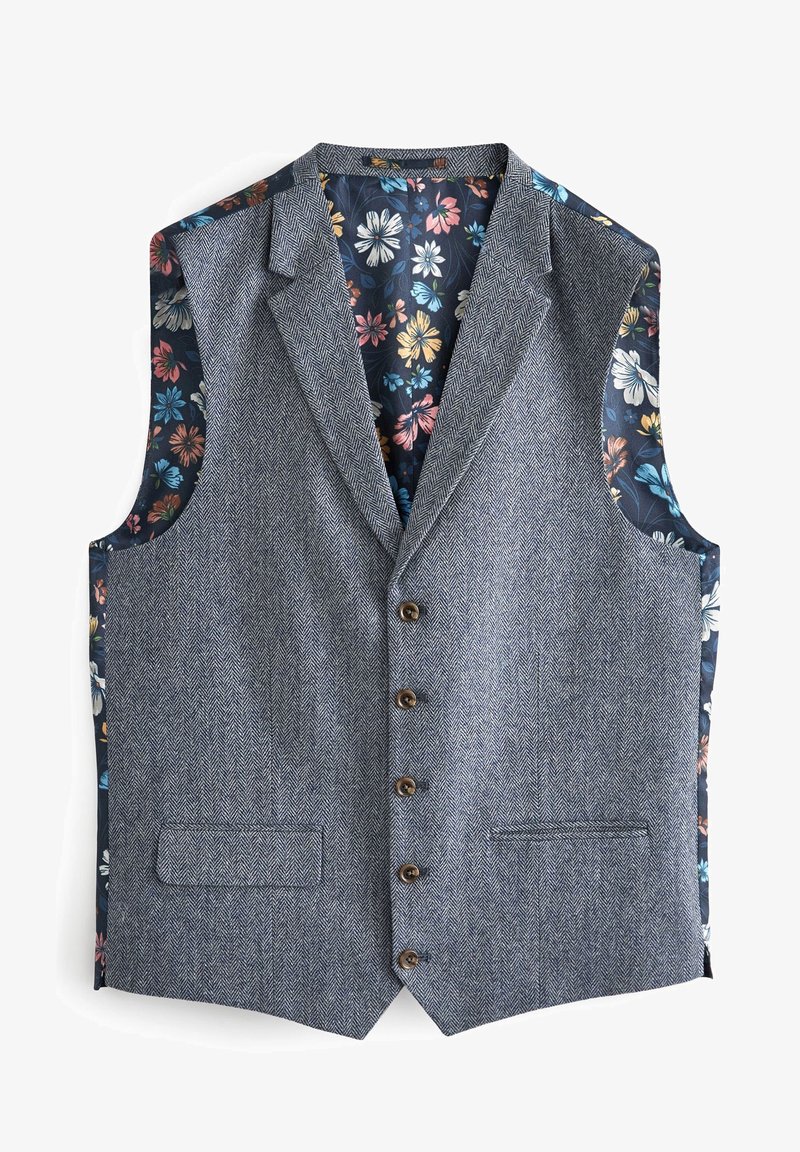 Kamizelka w szarym kolorze o wzorze jodełki, z niebieskim wnętrzem w kwiatowy wzór. Posiada pięć guzików i dwie boczne kieszenie. Bez rękawów.