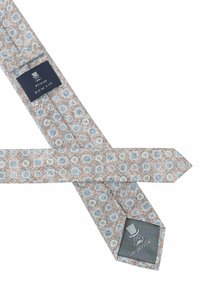 Beige Fliege mit einem kreisförmigen Muster in Himmelblau und Weiß. Der Stoff hat eine strukturierte Optik. Label sichtbar mit "Prince Bowtie."
