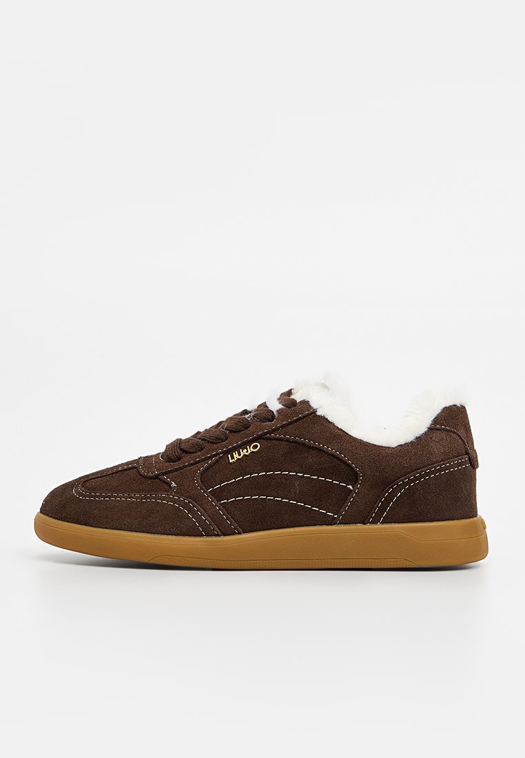Sneaker in suede marrone con fodera bianca pelosa, design con lacci, cuciture beige a contrasto e suola in gomma marrone. Logo del marchio visibile.