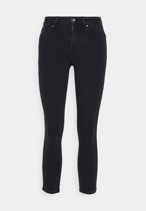 Jeans skinny pretos feitos de denim, com fecho de botão e zip, cinco bolsos e subtis detalhes de costura. Textura suave, forma ajustada.