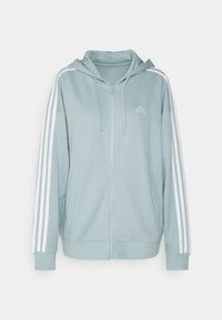 Světle modrá mikina na zip z měkké látky, s kapucí, bílými třemi pruhy na rukávech a vyšitým logem.