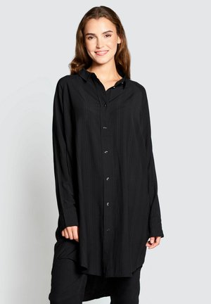 Schwarzes Langarmshirt mit durchgehender Knopfleiste, kragen und vertikalen Streifen. Bietet eine lässige Passform und kontrastierende Knopfdetails.