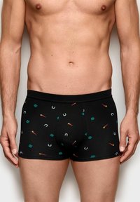 Sorte boxershorts med et mønster af grønne kløver, røde chili pebre og hestesko. Fremstillet af strækbart stof for komfort.