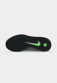 Μαύρη σόλα παπουτσιού με πράσινο λογότυπο Nike Swoosh και εξαγωνικό έμβλημα Nike, με λεπτές οριζόντιες αυλακώσεις για πρόσφυση.