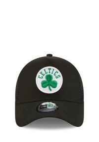 Black baseball cap featuring a white circular patch with a green shamrock and "CELTICS" text above it. Includes New Era adjustable hardware.