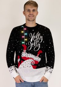 Schwarzer gestrickter Weihnachtspullover mit bunten Lichtern, dem Text "Holly Jolly", weißen Schneeflocken und einem Santa-Design am unteren Rand.