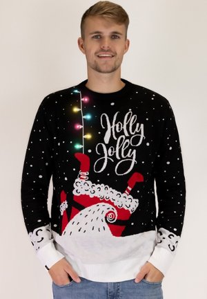Schwarzer gestrickter Weihnachtspullover mit bunten Lichtern, dem Text "Holly Jolly", weißen Schneeflocken und einem Santa-Design am unteren Rand.
