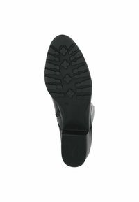 Sole di scarpa nera con superficie in gomma testurizzata, caratterizzata da una suola scolpita e un tacco basso a blocco. Presenta una leggera curvatura nella punta.
