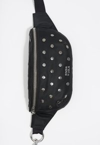 Czarna nylonowa torebka na ramię z metalicznymi ćwiekami, srebrnym zamkiem błyskawicznym i detalem z logo. Charakteryzuje się zaokrąglonym kształtem i regulowanym paskiem dla większej wszechstronności.